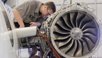 Aircraft mechanic installing the 400XTi left Williams FJ44 engine